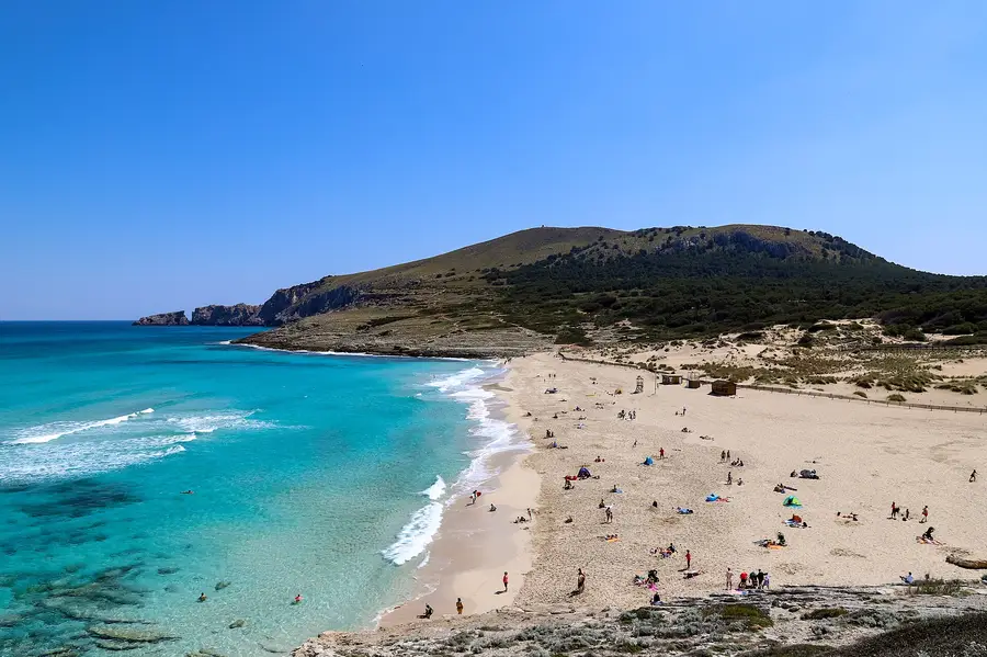 Die weite Bucht von Cala Mesquida mit türkisfarbenem Wasser und den geschützten Dünen, dahinter die Talaia de Son Jaumell