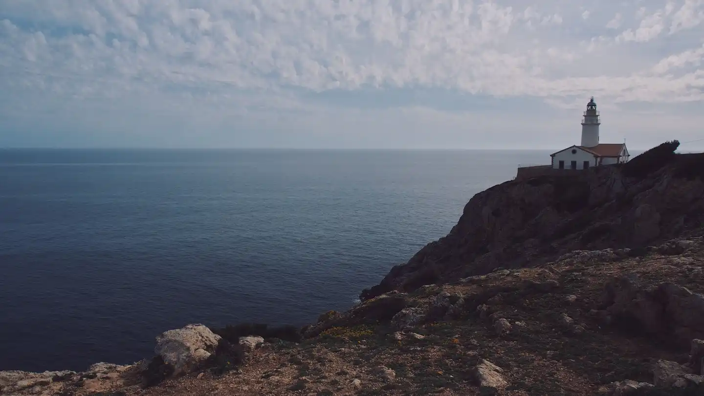 Der Leuchtturm Far de Capdepera auf der Landzunge über Cala Ratjada, dahinter das offene Meer