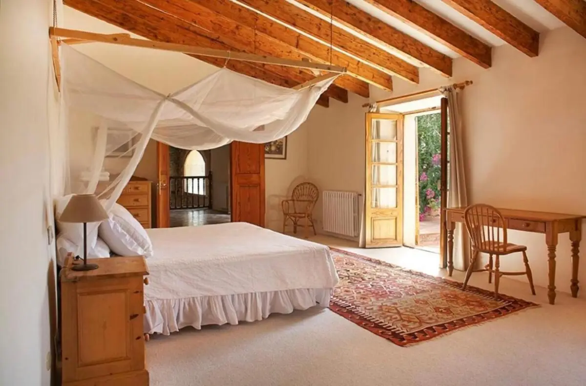 Schlafzimmer mit Himmelbett, Balkendecke und Flügeltüren ins Freie