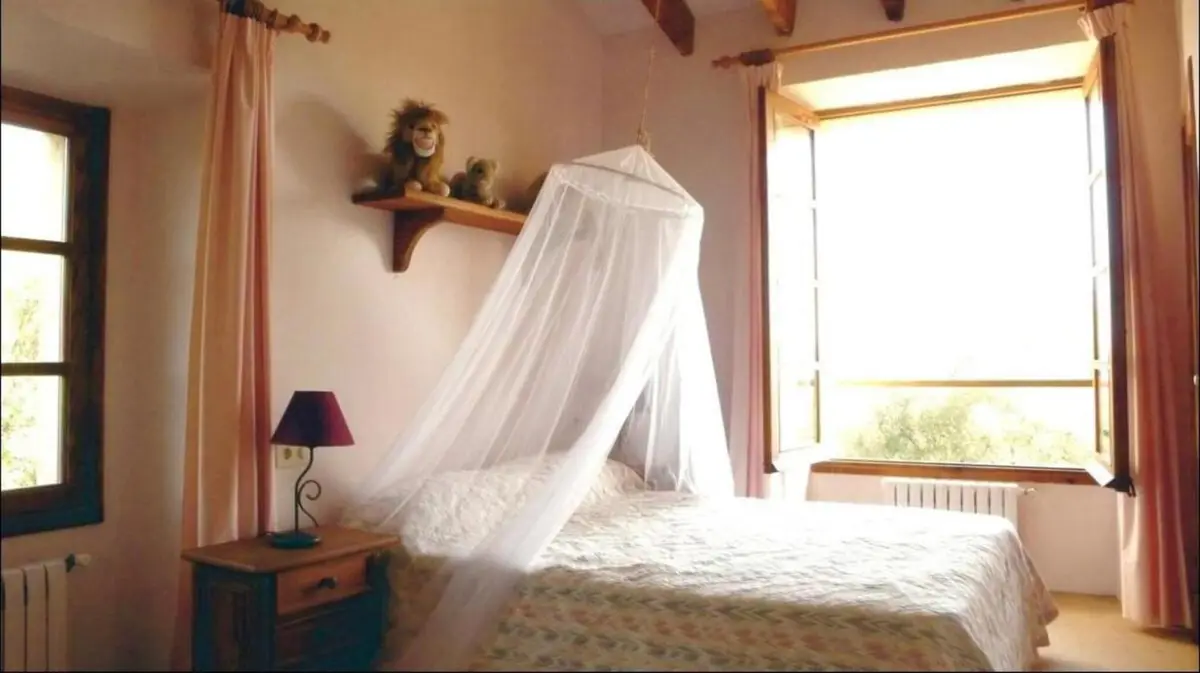 Schlafzimmer mit zwei Einzelbetten unter Moskitonetzen