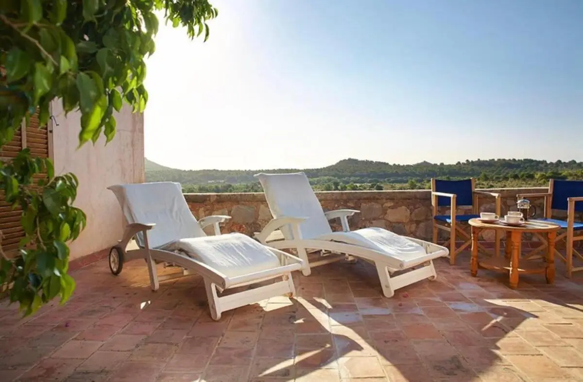 Terrasse mit Sonnenliegen und Sitzgruppe, Blick über das eigene Land